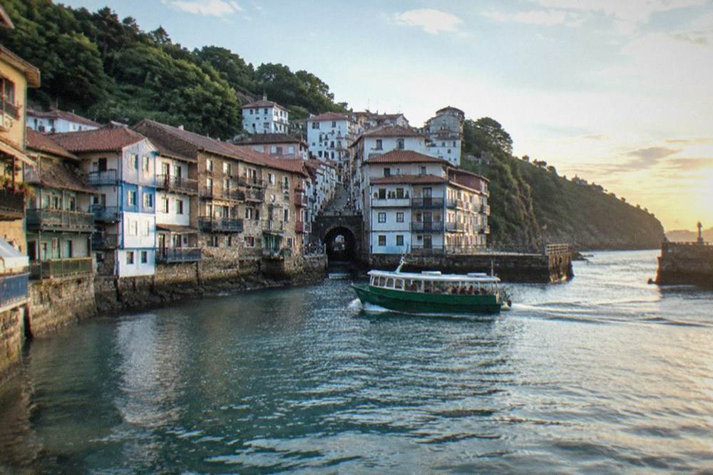 Narrow street of old houses rising behind the harbour front of Pasai Donibane