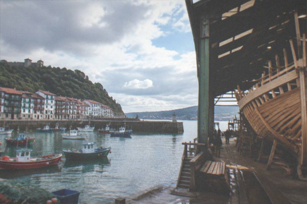 Timber frame of a wooden whaleship under construction inside a shipyard hall at the harbour