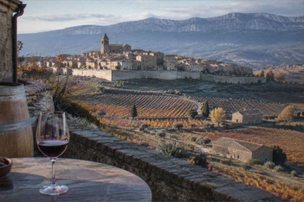 Glass of red Rioja wine on a tasting table beside a barrel