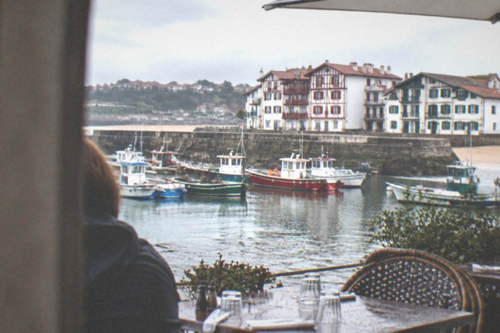 A restaurant terrace beside the harbour of Saint-Jean-de-Luz with tables set for lunch