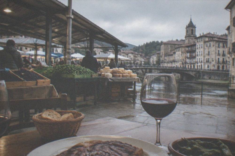 A table set with grilled steak and red wine in a rustic Basque restaurant