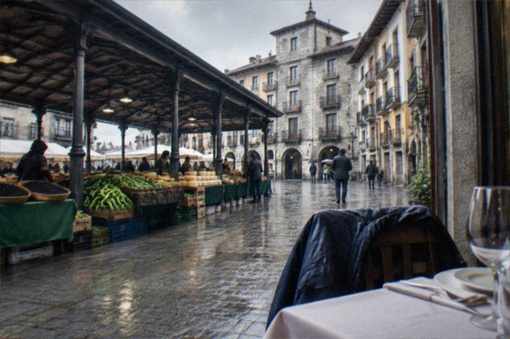 A waterproof jacket hanging on the back of a chair beside a table set for lunch in a restaurant window