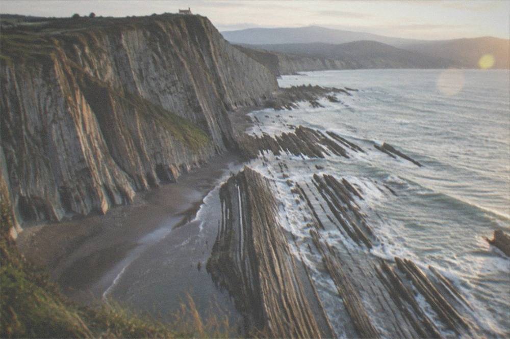A sandy beach backed by steep layered cliffs at Itzurun in Zumaia