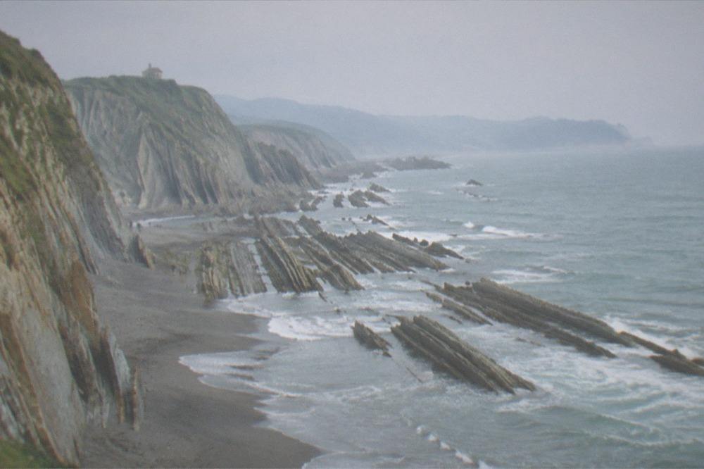 Sunlight on layered cliffs above the sea on the Gipuzkoa coast