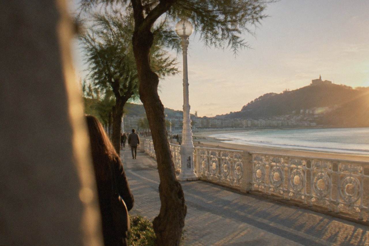 Golden evening light over La Concha bay in San Sebastián with the beach promenade and Monte Igueldo in the distance