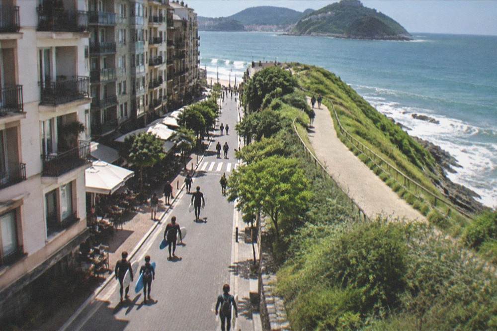 Coastal walking path above green cliffs with the sea beyond, on the route east of the city