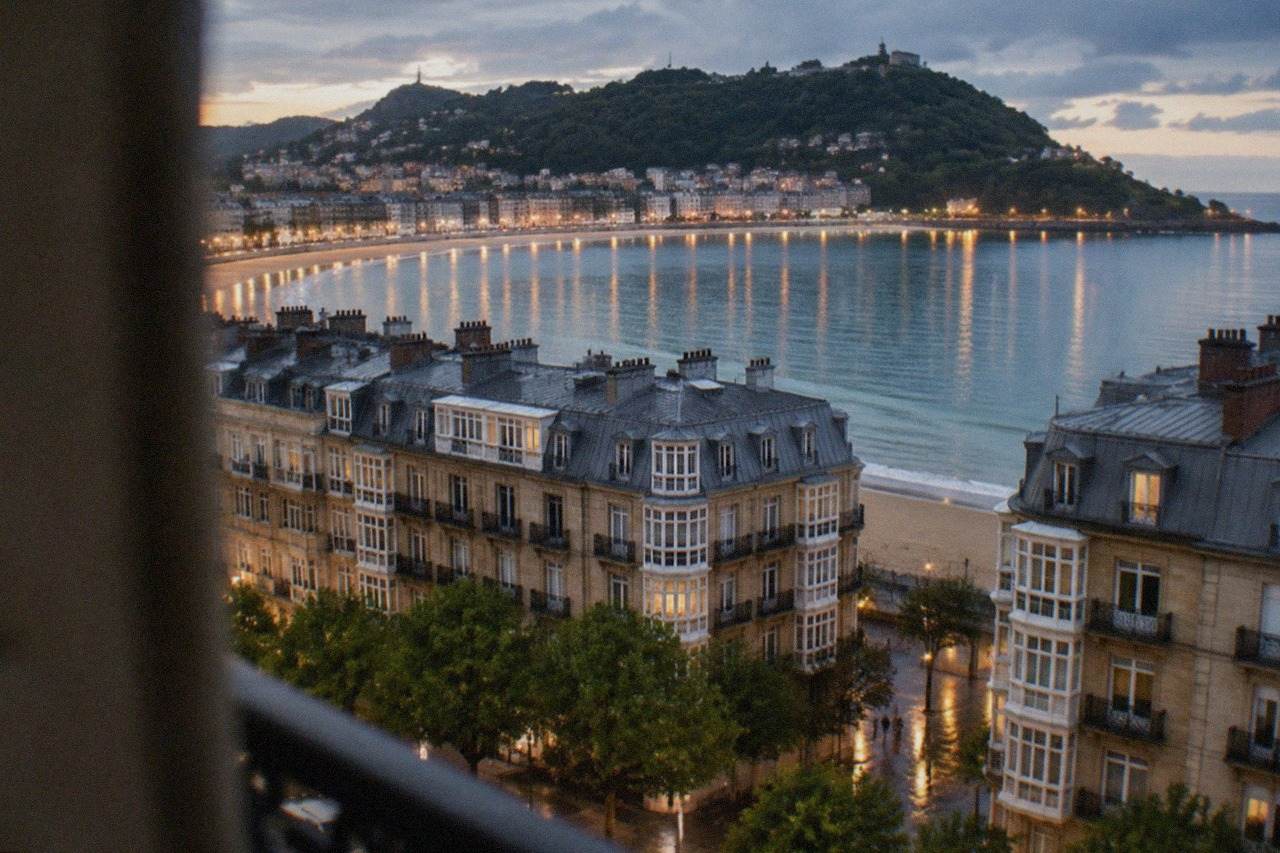Evening view over the rooftops and bay of San Sebastián with lights reflecting on the water