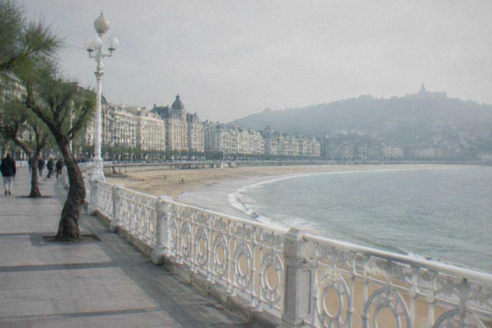 The sandy arc of La Concha beach with the promenade railing and hotel facades behind