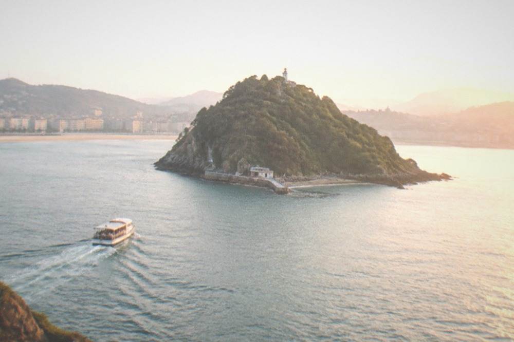 Golden evening light over La Concha bay with Santa Clara island in the middle of the water