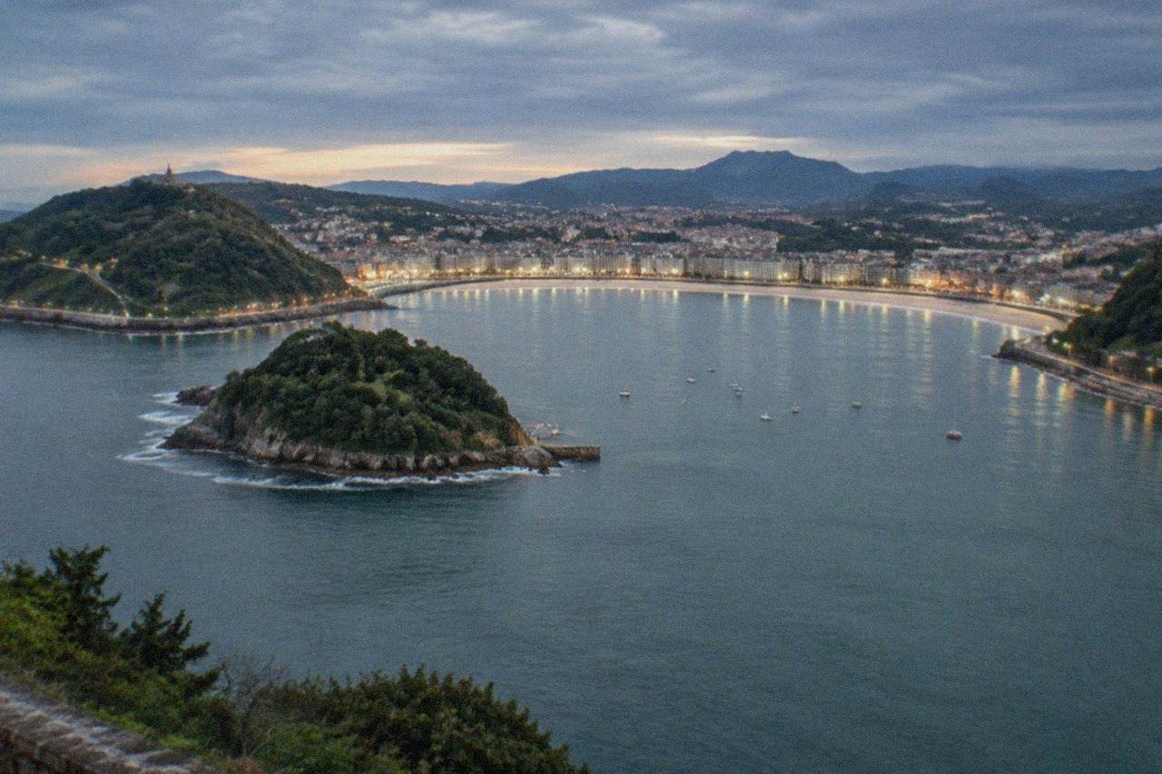 Evening view over La Concha bay in San Sebastián with the illuminated seafront and hills