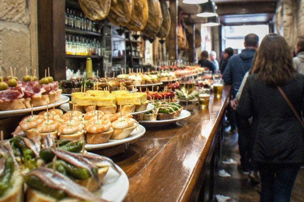 A pintxo bar counter in the Old Town of San Sebastián loaded with small skewered bites