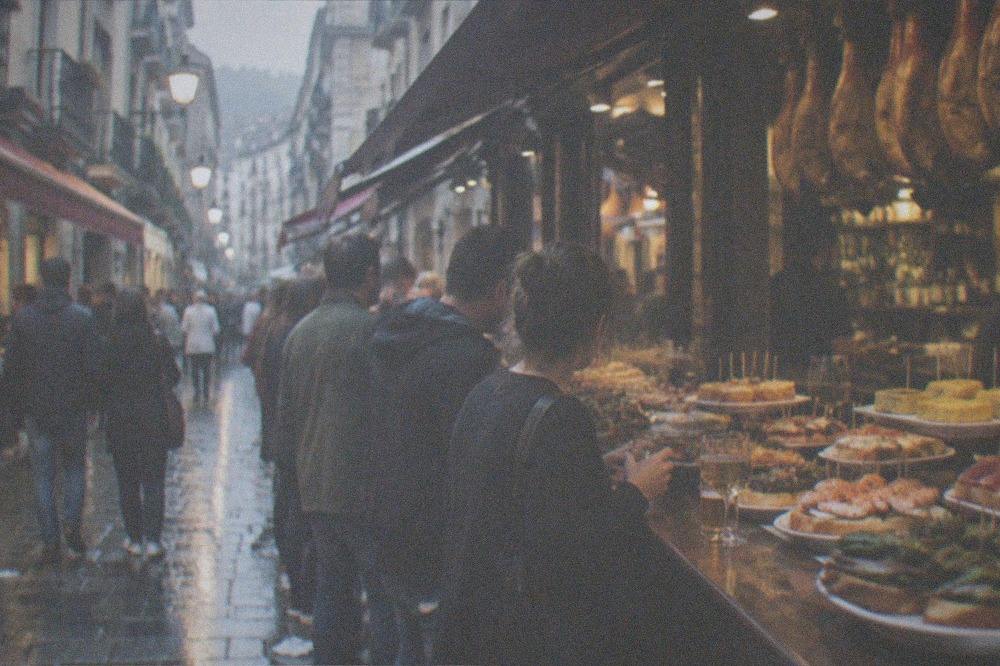 A narrow Old Town street in San Sebastián lined with pintxo bar awnings at dusk