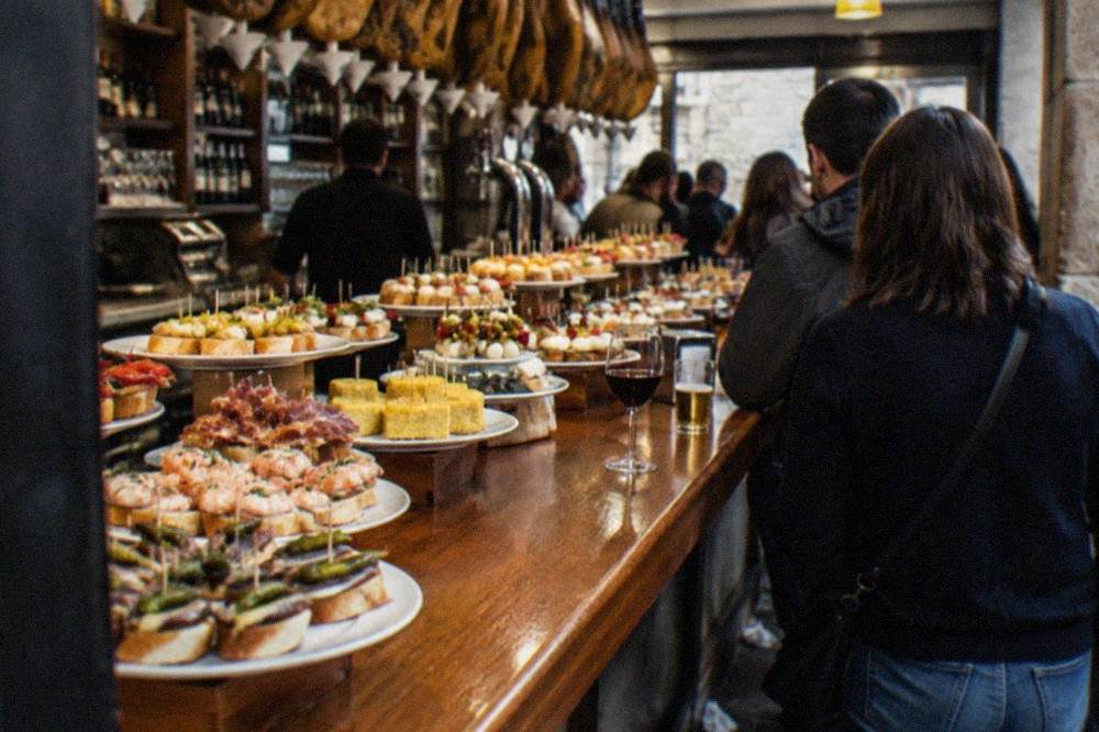 A pintxo bar counter in the Parte Vieja with small skewered snacks and glasses of wine laid out