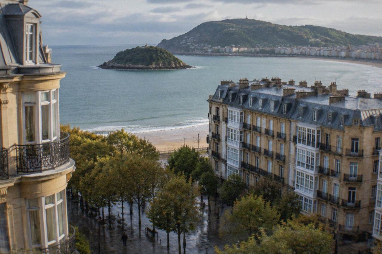 The curved bay of San Sebastián seen from above, with the island and green hills behind the water