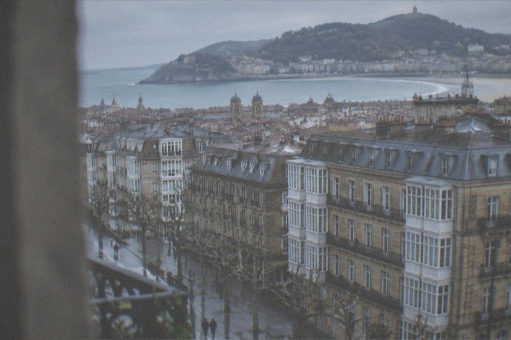 The walled old town rooftops of San Sebastián with the bay and hills beyond