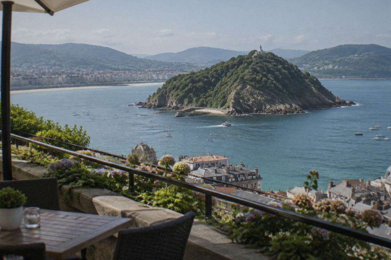 A small hotel terrace above the rooftops of San Sebastián with La Concha bay and Santa Clara island in the background