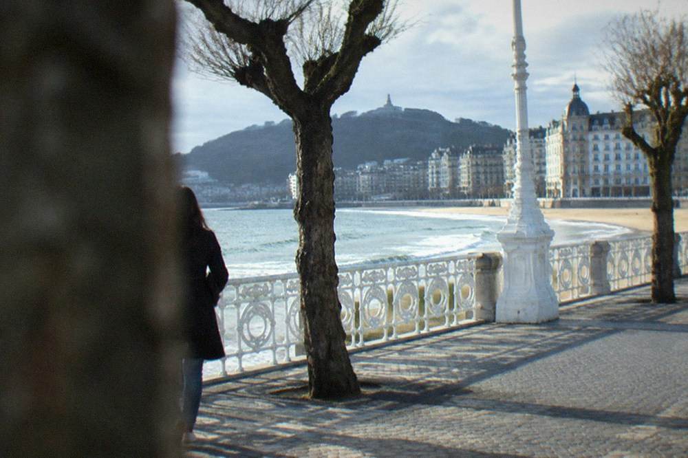 The La Concha promenade in San Sebastián with white railings, the beach and a hotel facade behind it