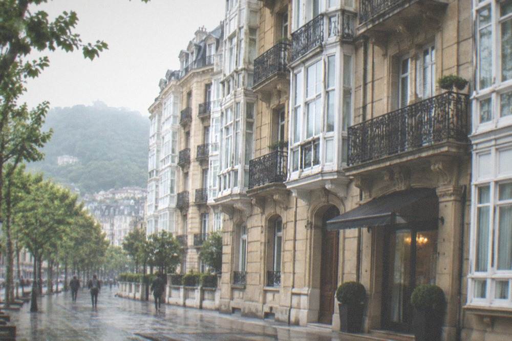 A belle époque building facade in central San Sebastián with wrought iron balconies above a small hotel entrance