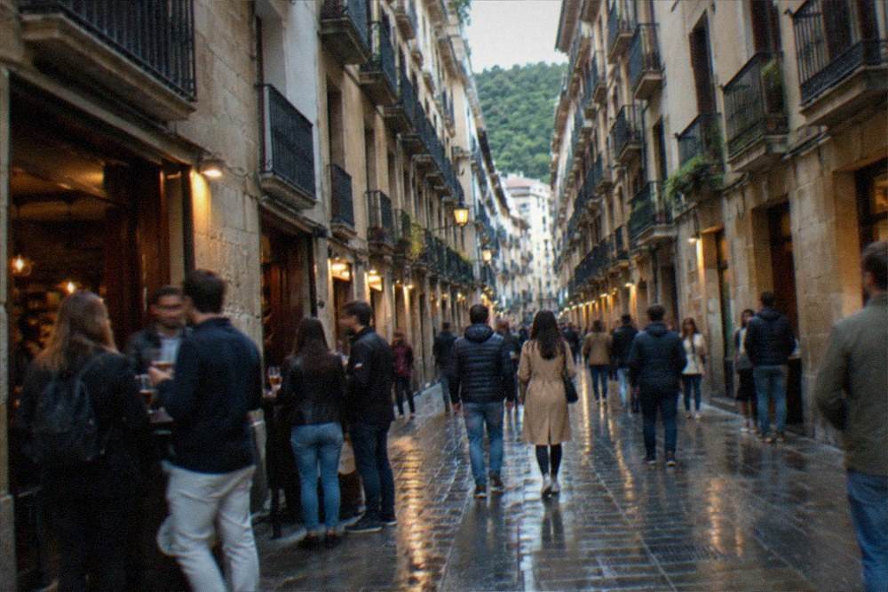 A narrow Old Town street with bar fronts and people walking in the evening