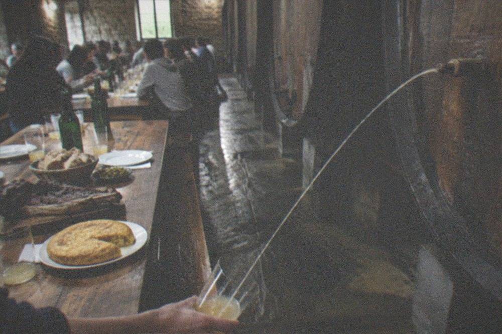 Long wooden tables set for a group meal in a rustic cider house dining room