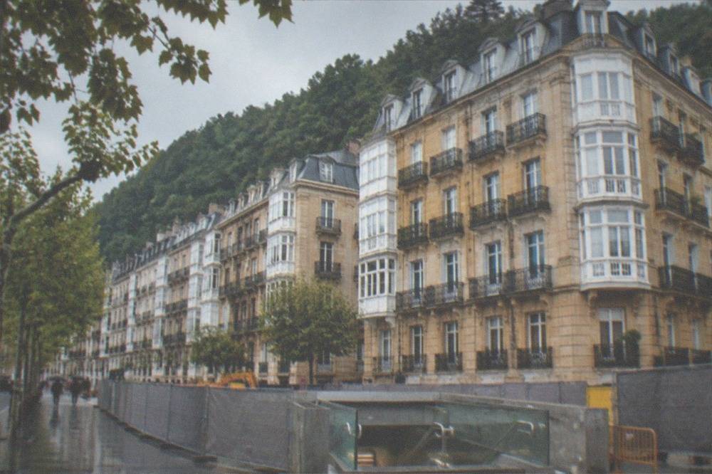 Construction fencing and station entrance works beside a city street in San Sebastián