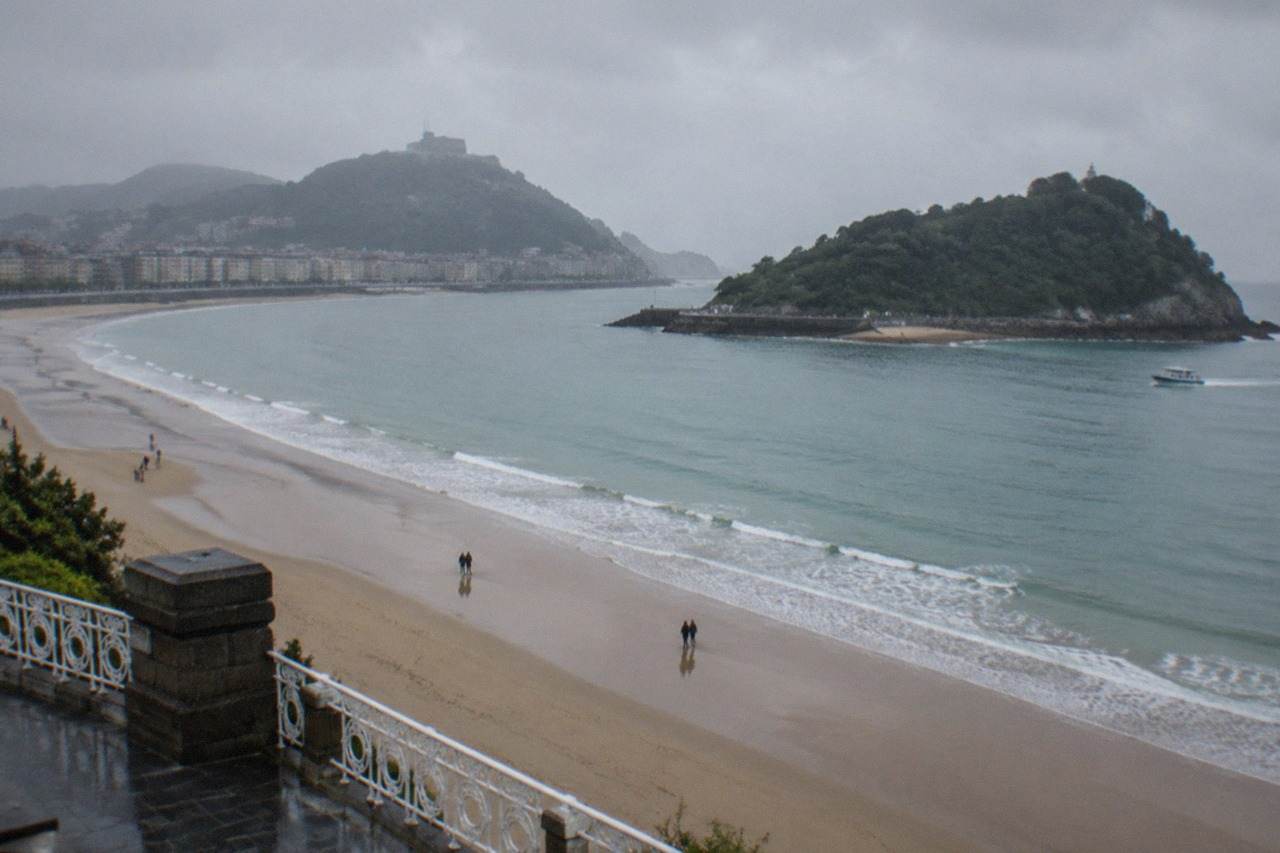 The wide sandy curve of La Concha beach in San Sebastián with the bay and Santa Clara island behind it