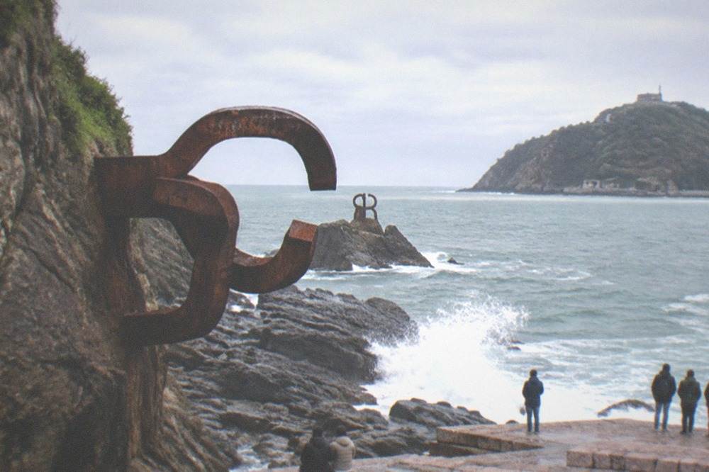 Chillida's curved steel sculptures of the Peine del Viento standing on the rocks at the end of Ondarreta beach