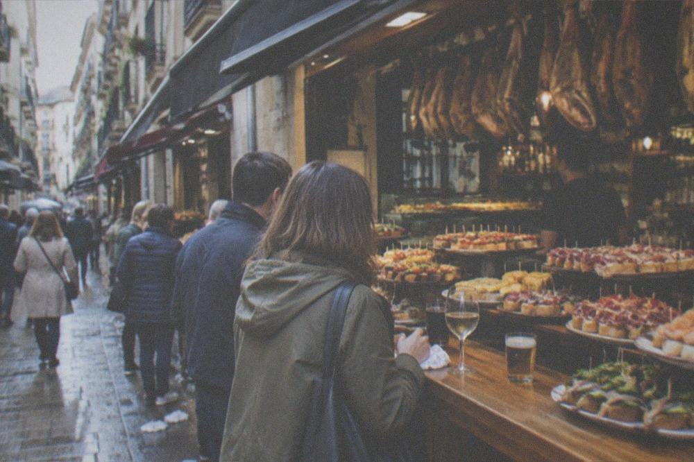 A narrow Old Town street in San Sebastián with pintxo bar awnings and balconies above