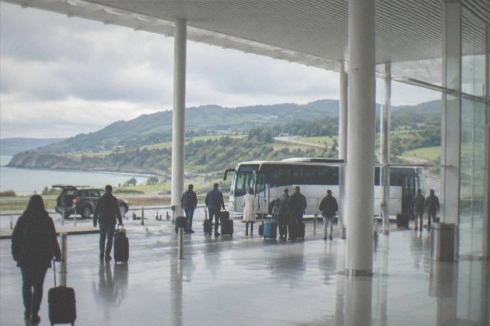 Green hills and a winding road above the Basque coastline on a cloudy day