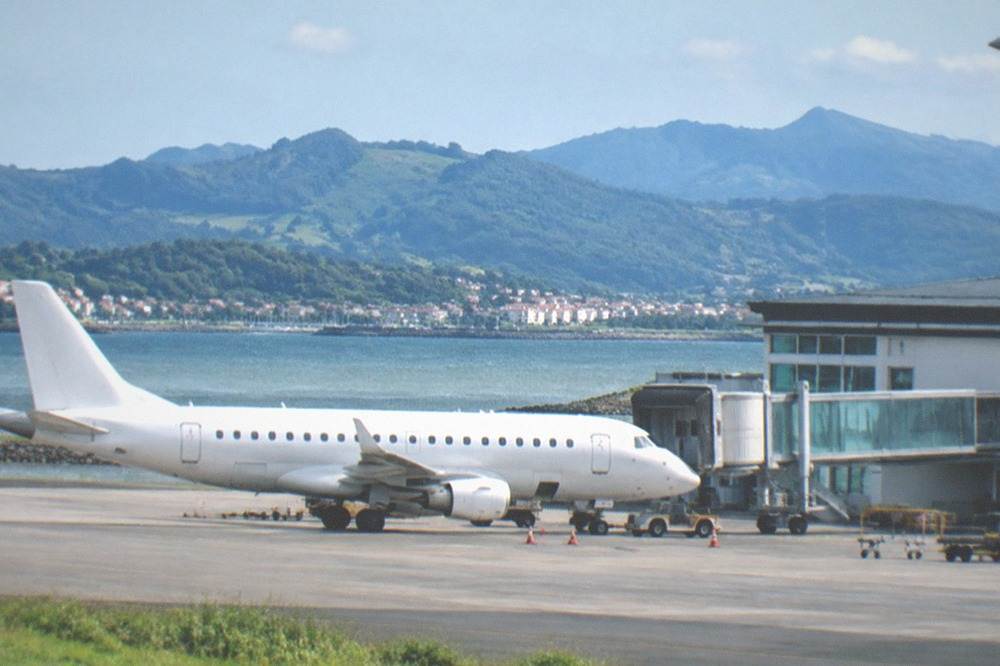Small regional airport building with a single aircraft at the gate