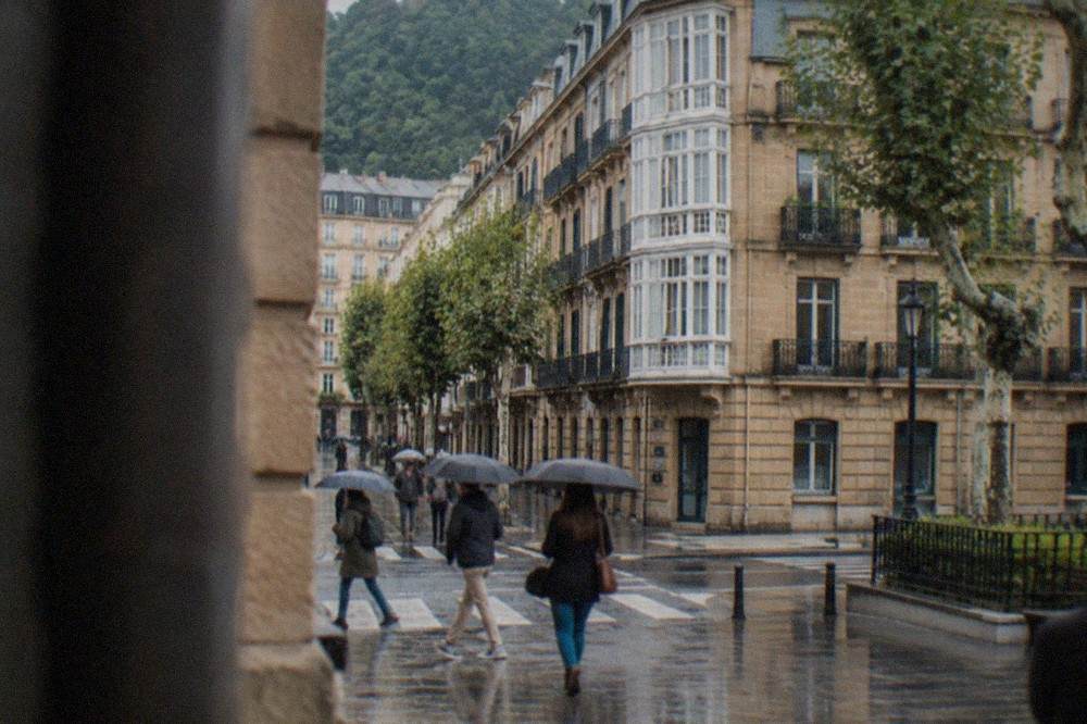 Pedestrians crossing a narrow street in the Old Town of San Sebastián