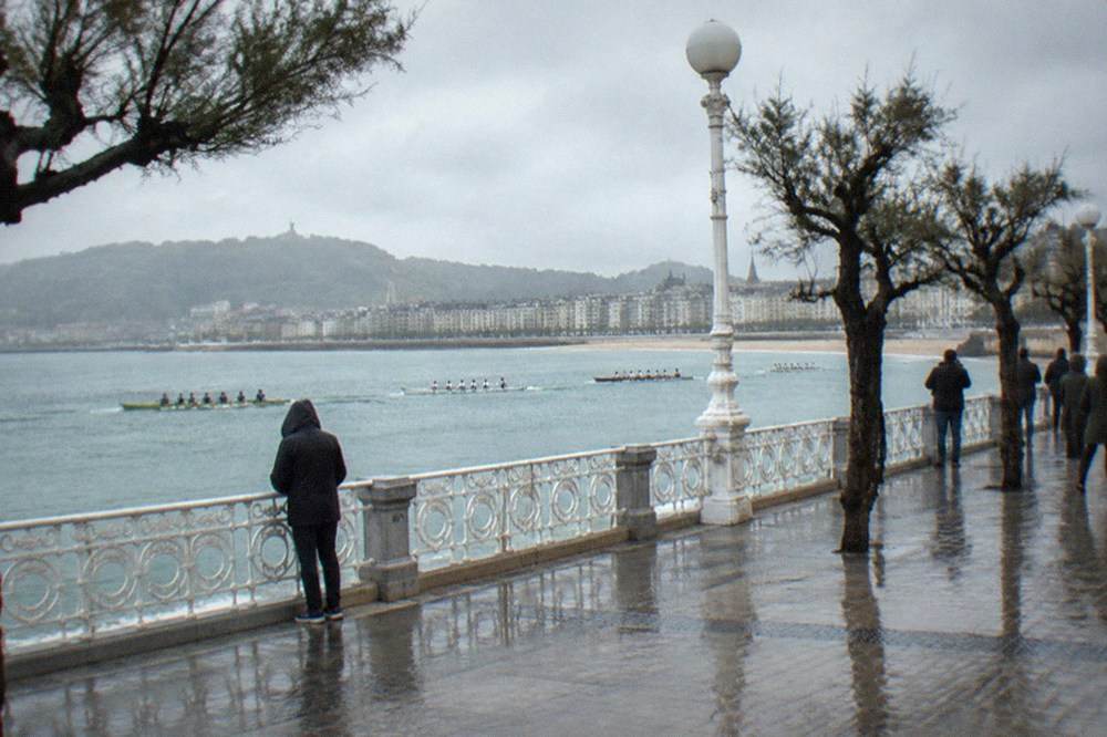 Rowing teams racing on La Concha bay watched from the seafront promenade