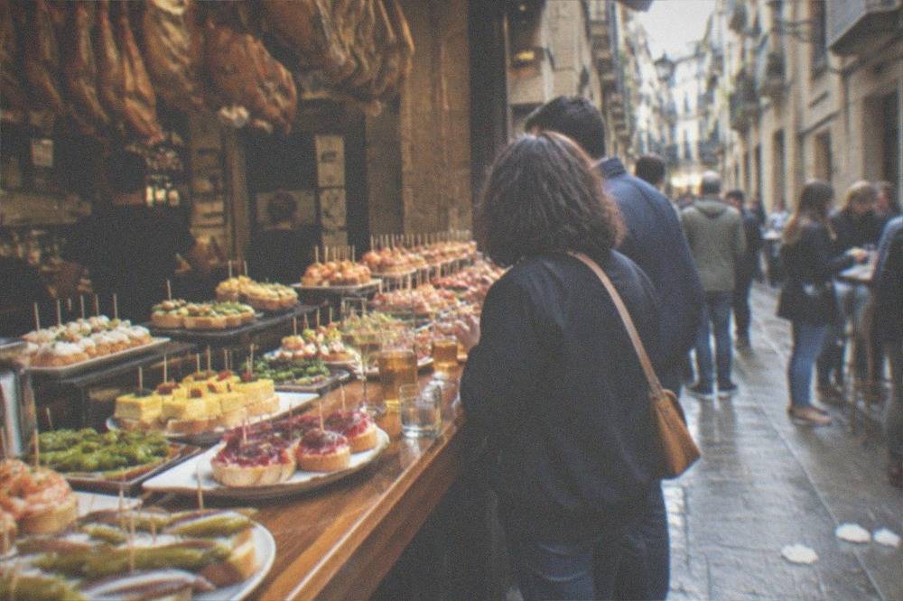 Narrow Old Town streets in San Sebastián lined with pintxo bars and people standing outside with small plates