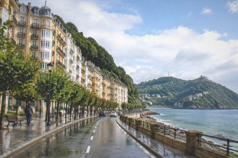 A coastal road with green hills above the Bay of Biscay seen on a day trip from San Sebastián