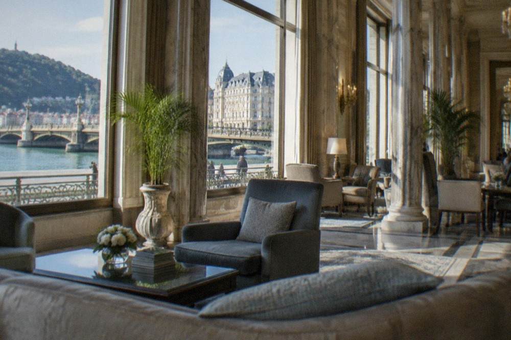 Hotel lobby with marble columns, tall windows and formal seating