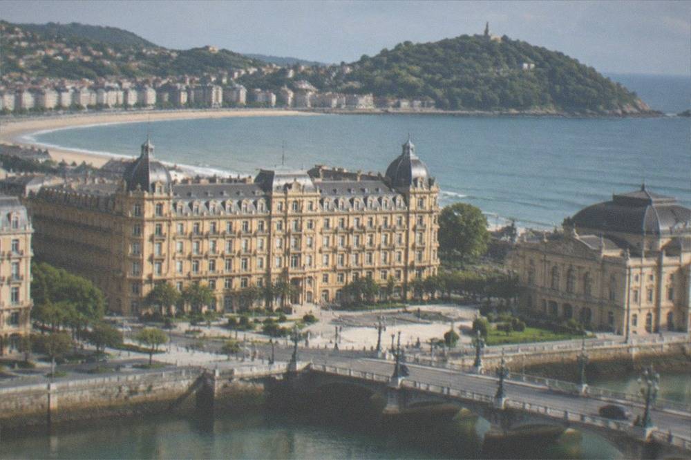 Evening view over a city bay with a curved beach and island