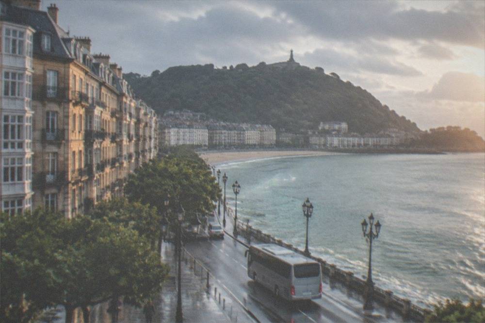 A coach driving along a coastal road with the Bay of Biscay to one side