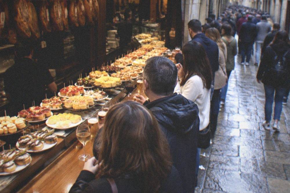 Evening crowds outside pintxo bars on a narrow street in the Old Town