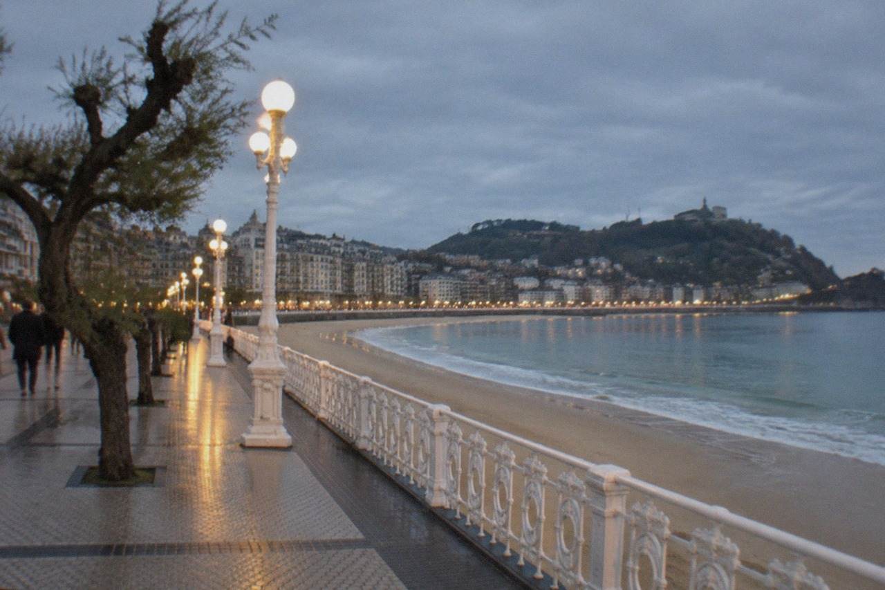 Evening view over La Concha bay in San Sebastián with the beach promenade lit up