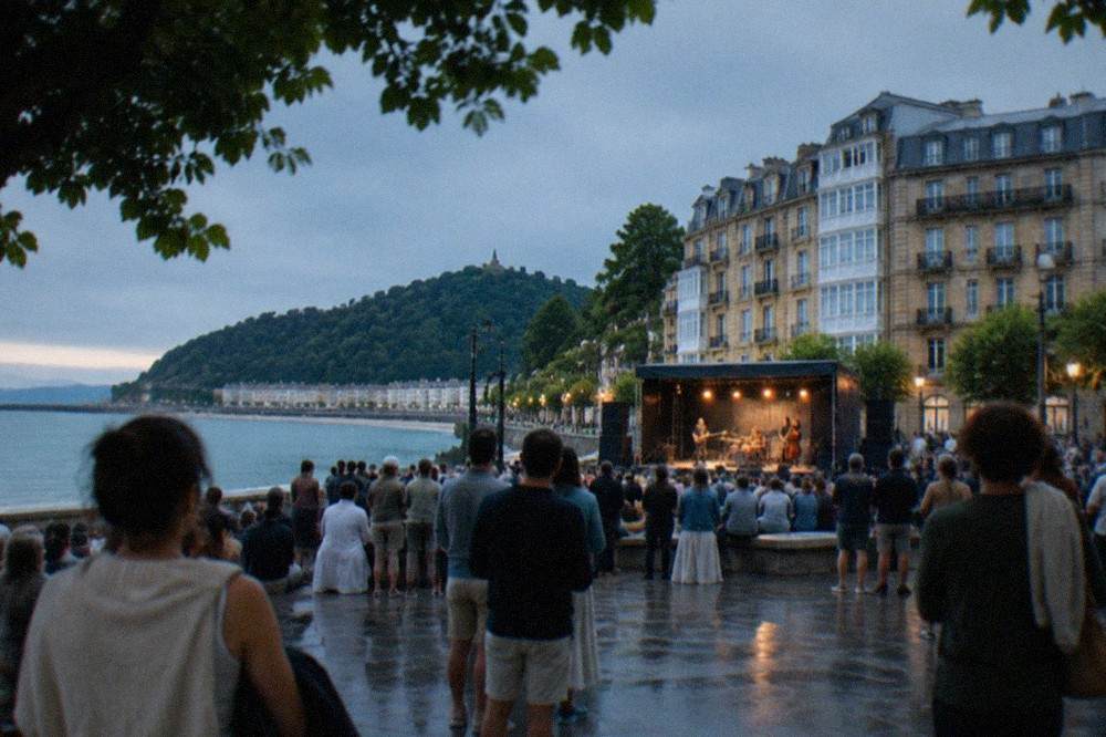 Crowd listening to a concert on a seaside plaza in San Sebastián