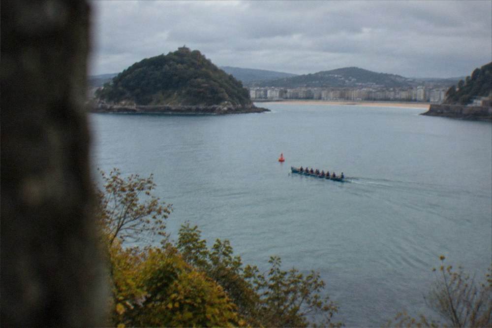A trainera rounding the buoy in the middle of La Concha bay seen from high on the hillside