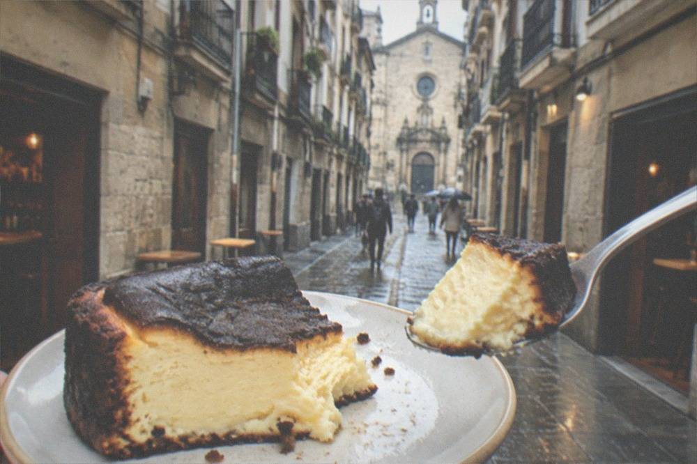 A spoon lifting a soft interior piece of burnt cheesecake showing the contrast with the dark crust