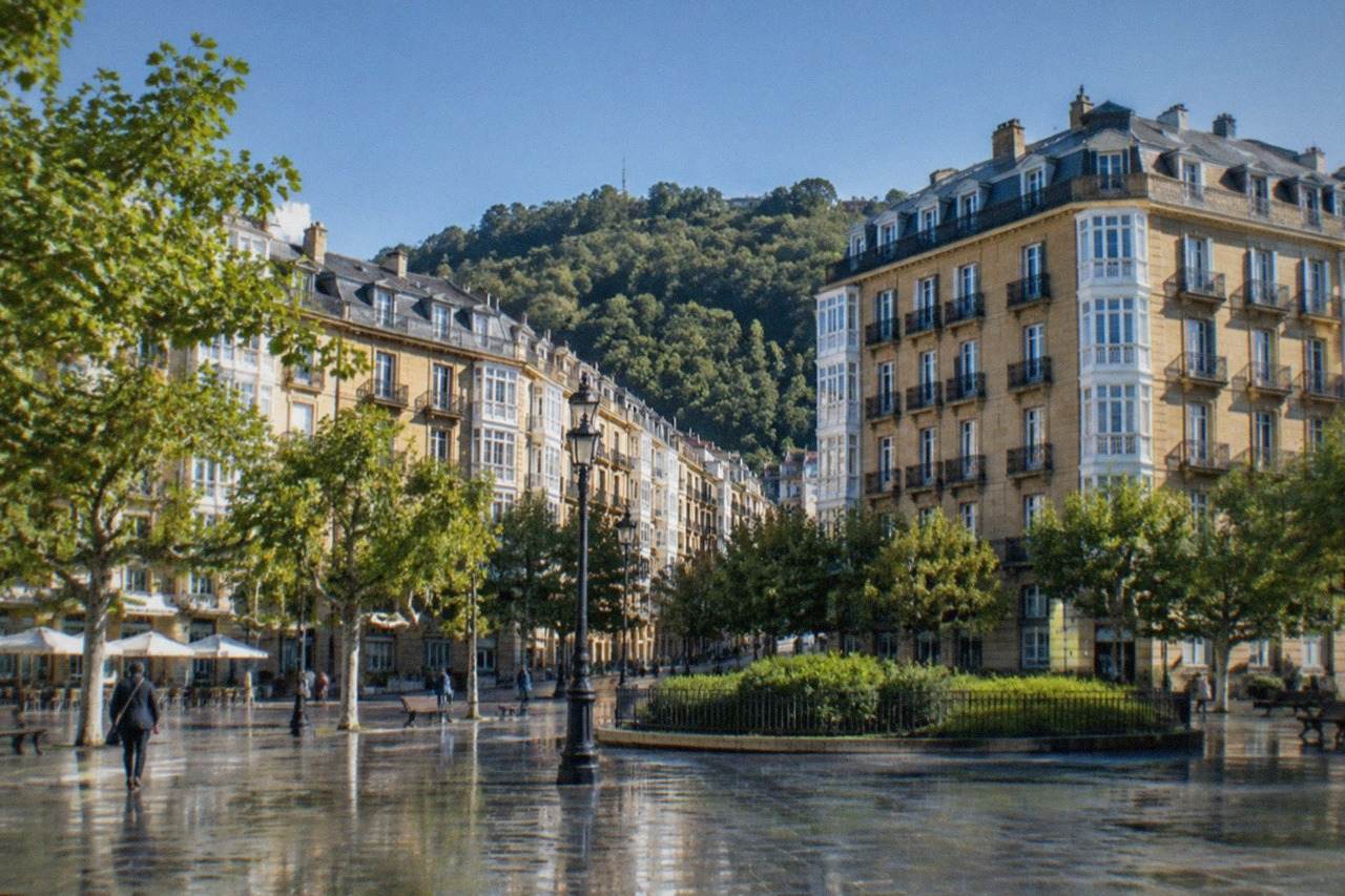 A sunny square in San Sebastián with bilingual street signs in Basque and Spanish