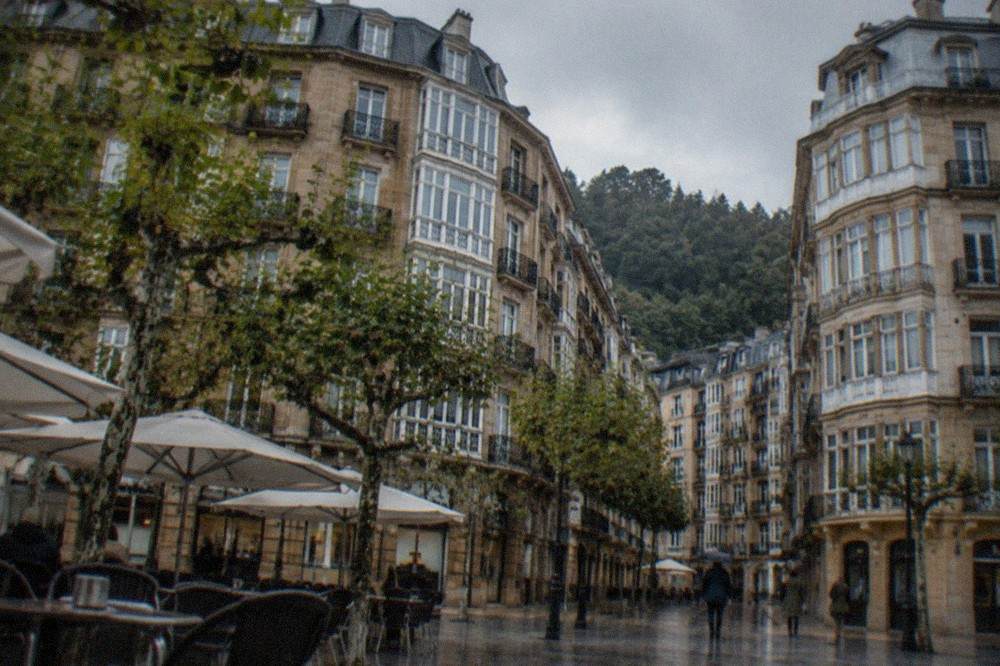 A cafe terrace in the Old Town of San Sebastián with a chalkboard menu written in Basque and Spanish