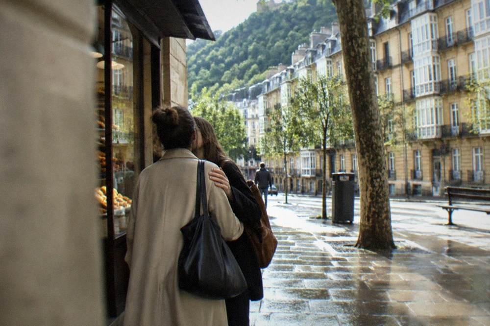 Two friends greeting each other outside a bakery in San Sebastián in the morning
