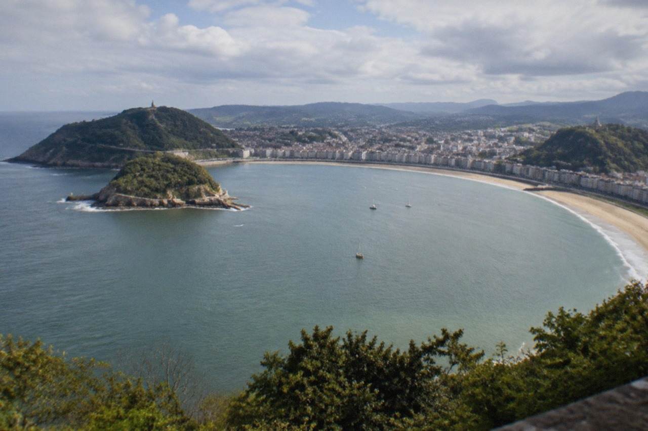 La Concha bay in San Sebastián seen from above, with the beach curving between Monte Igueldo and Monte Urgull