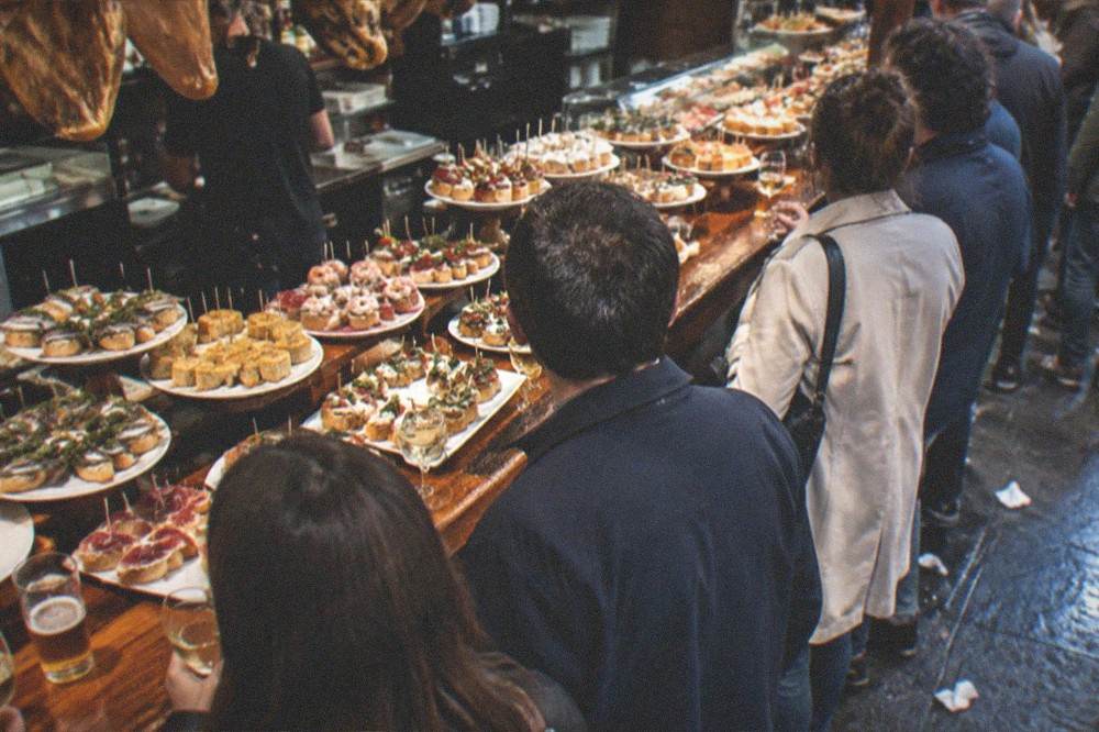 A pintxo bar counter in the Old Town with small skewered dishes on display