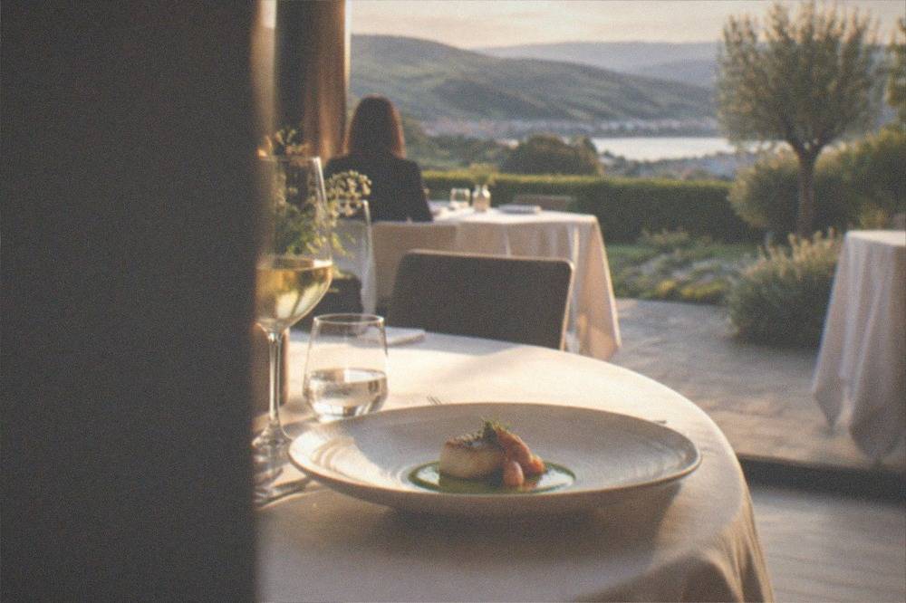 A plated tasting dish with seafood and green sauce on a white ceramic plate