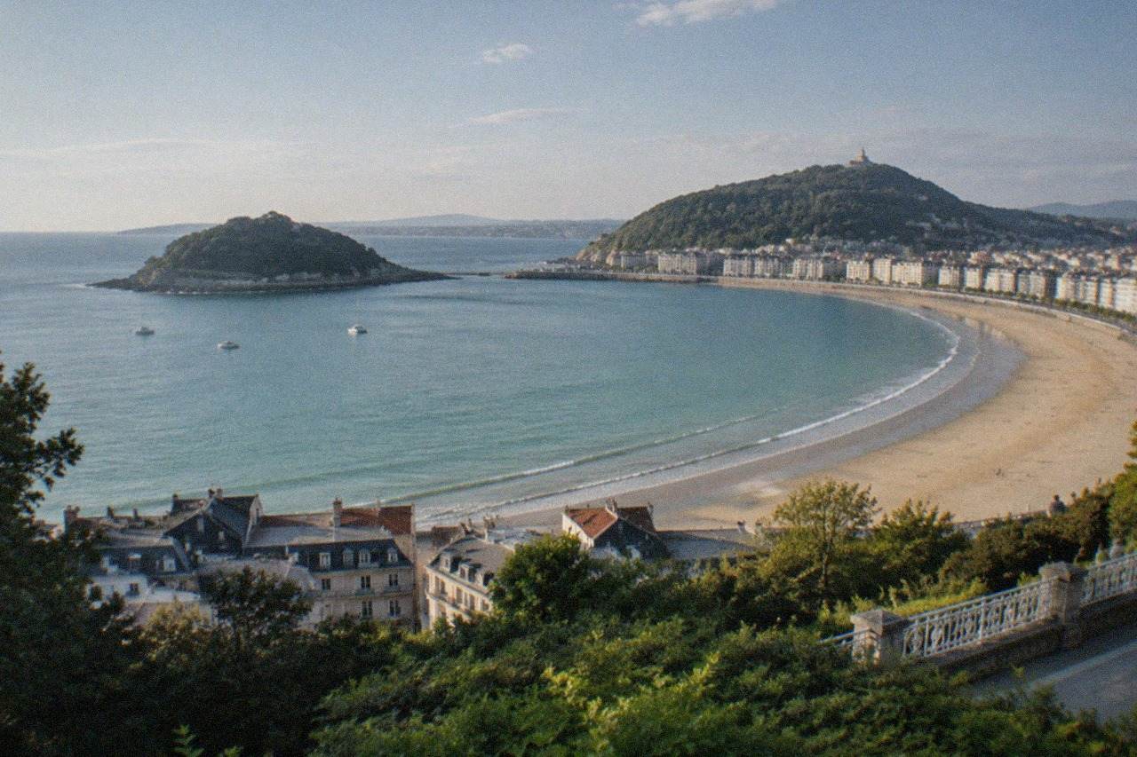 Evening view over the illuminated bay and rooftops of San Sebastián from a hillside above La Concha