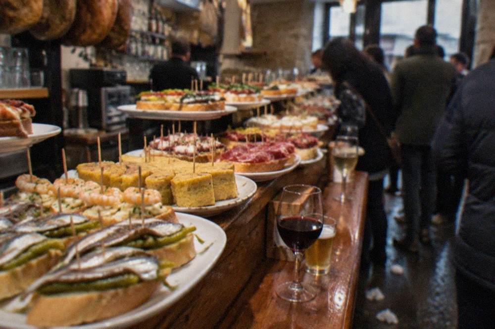 Close view of pintxos on a bar counter with toothpicks and small slices of bread